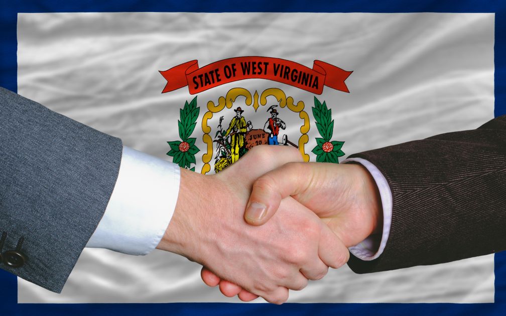 Handshake in front of West Virginia Flag